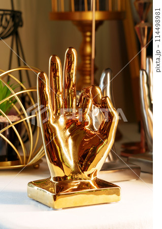 Golden Hand Sculpture on Display in a Cozy Indoor Setting at Dusk Golden Hand Sculpture on Display in a Cozy Indoor Setting at Dusk 114498981