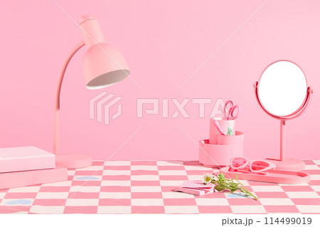 Some personal necessaries in pink color featured on the table has checkered pattern, on light pink background. Pink color concept for advertising, blank space in center for presentation 114499019