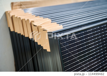 Close-up new solar panels with protective cardboard corners, ready for installation. Renewable energy technology, green living, and the implementation of solar power in residential areas. 114499482