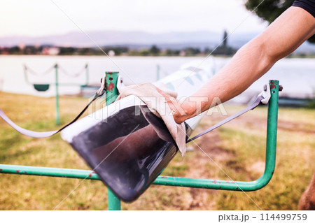 Young canoeist taking care of his canoe and paddle, cleaning, drying. Concept of canoeing as dynamic and adventurous sport Young canoeist taking care of his canoe and paddle, cleaning, drying. Concept of canoeing as dynamic and adventurous sport 114499759
