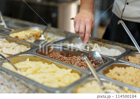 Chef Serving Freshly Cooked Dishes at a Restaurant Buffet During Lunchtime Chef Serving Freshly Cooked Dishes at a Restaurant Buffet During Lunchtime 114500184