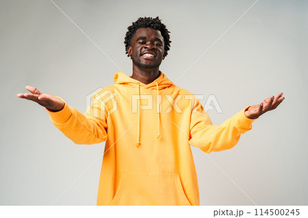 Man in Yellow Hoodie With Hands Out 114500245