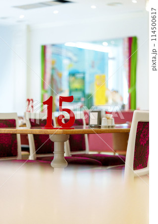 Vibrant Restaurant Interior With Red Number 15 on Table and Colorful Artwork in Background Vibrant Restaurant Interior With Red Number 15 on Table and Colorful Artwork in Background 114500617