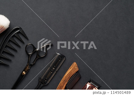 An Assortment of Professional Hairdressing Tools Laid Out on a Dark Surface An Assortment of Professional Hairdressing Tools Laid Out on a Dark Surface 114501489