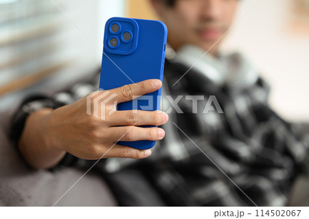 Select focus on hand of hipster man holding smartphone, scrolling and texting in social networks 114502067