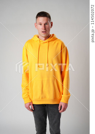 Portrait of surprised young man with shocked facial expression against gray background 114502072