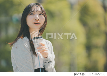 テイクアウトの紙カップを持った若い働く女性 114502739