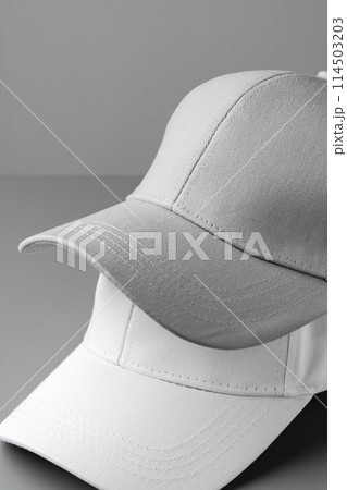 Two White Baseball Caps on a White Background 114503203