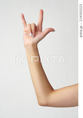 Female hand gesturing rock and roll on white background Female hand gesturing rock and roll on white background 114503223