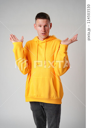 Portrait of surprised young man with shocked facial expression against gray background Portrait of surprised young man with shocked facial expression against gray background 114503530