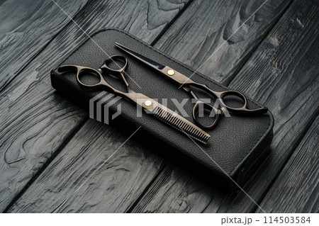 Hairdressing scissors on black wooden background close up Hairdressing scissors on black wooden background close up 114503584