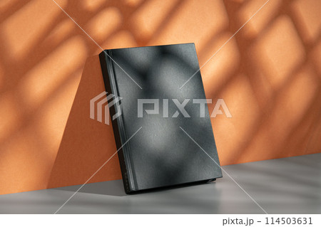 Black notepad mock up against terracotta wall 114503631