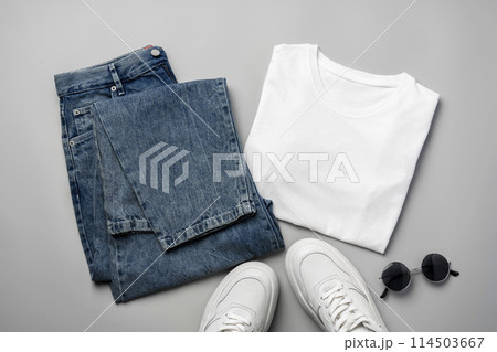 T-shirt, jeans and white sneakers on gray background top view 114503667