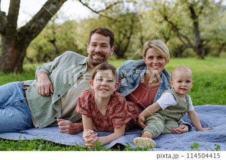 Family portrait with daughter and small toddler, baby, outdoors in spring nature. 114504415
