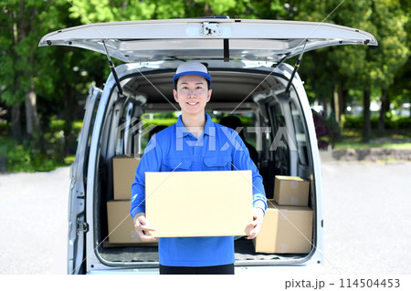 屋外で荷物を運ぶ配送ドライバーの男性 屋外で荷物を運ぶ配送ドライバーの男性 114504453