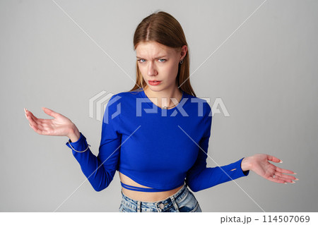 Young Woman in Blue Top Holding Out Hands Young Woman in Blue Top Holding Out Hands 114507069