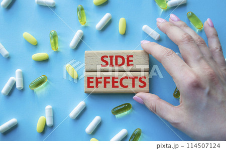 Side Effects symbol. Wooden blocks with words Side Effects. Beautiful blue background with pills. Doctor hand. Medicine and Side Effects concept. Copy space. 114507124
