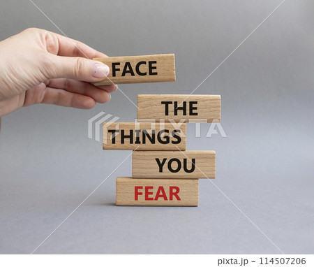 Face the things you fear symbol. Wooden blocks with words Face the things you fear. Beautiful grey background. Businessman hand. Business and Face the things you fear concept. Copy space. 114507206