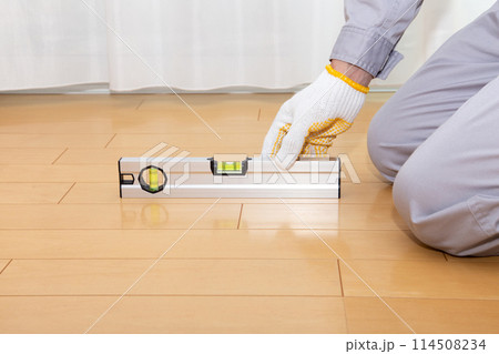 水平器（水準器、レベル）を使って床の水平を調べる業者 114508234