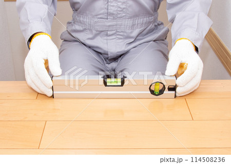 水平器（水準器、レベル）を使って床の水平を調べる業者 114508236