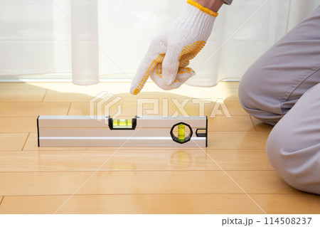 水平器（水準器、レベル）を使って床の水平を調べる業者 114508237