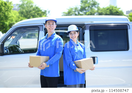 屋外で荷物を運ぶ配送ドライバーの男女 114508747