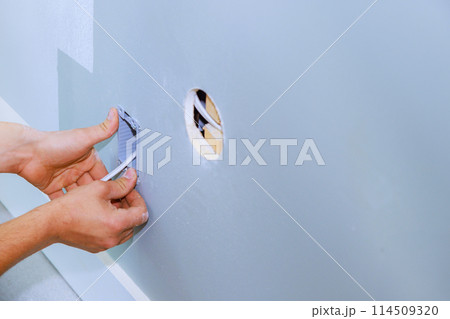 An electrician installed new current socket box during renovation of in apartment An electrician installed new current socket box during renovation of in apartment 114509320
