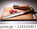 a bloody knife with a severed ear on a cutting board	 114510401
