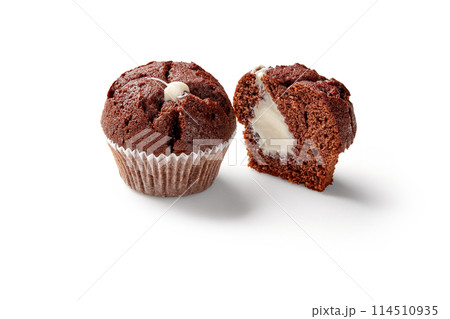 Whole and sliced chocolate muffins with creamy filling 114510935