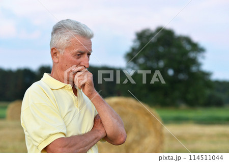Serious senior man thinking in park on green background 114511044