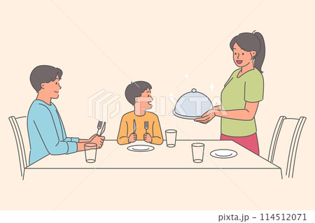 Caring woman serves dinner to husband and son sitting at table, during family holiday 114512071