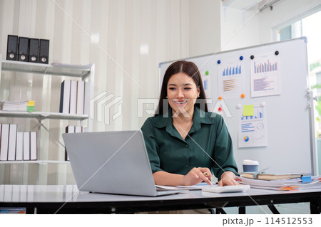 Businesswoman accountant using calculator and laptop for financial data saving in office room, Business financial, tax, accounting concept 114512553