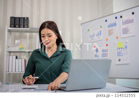 Businesswoman accountant using calculator and laptop for financial data saving in office room, Business financial, tax, accounting concept 114512555