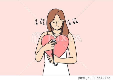 Woman listens to own heart using stethoscope to maintain spiritual harmony and psychological health 114512772