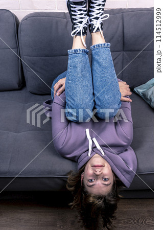 teenage girl, lying on the couch upside down 114512999