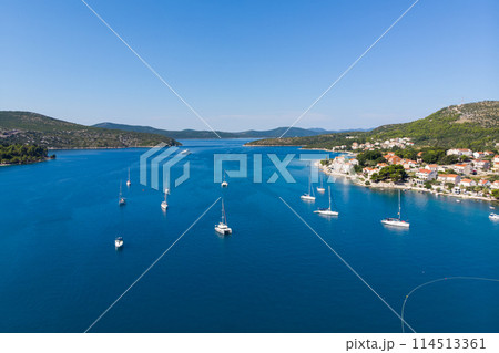 Scenic aerial view many yachts boats moored at Croatian bay harbor shore blue turquoise clear water at bright summer sunny day. Top above Mediterranean sea marina. Boat vessel charter service 114513361