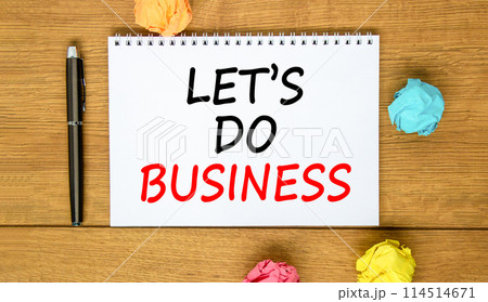 let is do business symbol. Concept words let is do business on beautiful white note. Beautiful wooden background. Black pen. Colored paper. let is do business concept. Copy space. 114514671