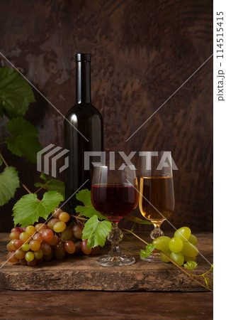 Still life with glasses of red and white wine and grapes on vintage wooden background.. 114515415