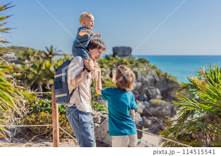 Father and two sons tourists enjoying the view Pre-Columbian Mayan walled city of Tulum, Quintana Roo, Mexico, North America, Tulum, Mexico. El Castillo - castle the Mayan city of Tulum main temple 114515541