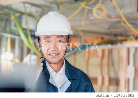建設現場で資材を運搬する大工さん 建設現場で資材を運搬する大工さん 114515602