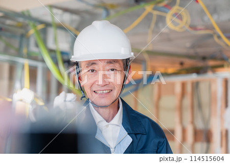 建設現場で資材を運搬する大工さん 建設現場で資材を運搬する大工さん 114515604