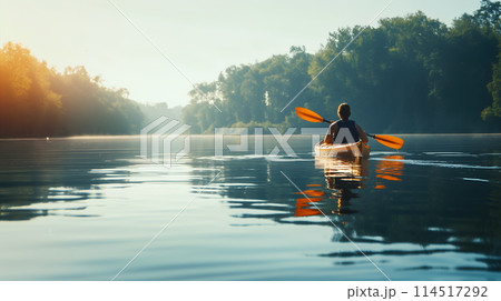 Solitary Kayaker Paddles on a Serene Lake at Golden Hour Solitary Kayaker Paddles on a Serene Lake at Golden Hour 114517292