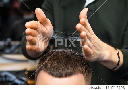 Hairdresser adjusts freshly cut hair of client in barbershop closeup. Careful stylist tousles haircut serving man in grooming salon Hairdresser adjusts freshly cut hair of client in barbershop closeup. Careful stylist tousles haircut serving man in grooming salon 114517408