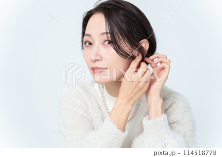 イヤリングを付けるショートヘアの女性 114518778