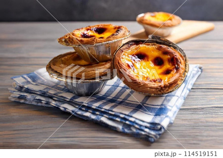Custard tarts on a checkered cloth, wooden backdrop Custard tarts on a checkered cloth, wooden backdrop 114519151