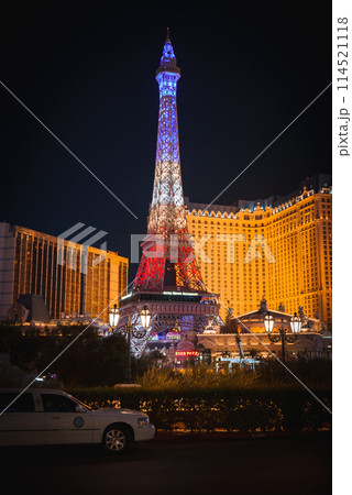Vibrant Las Vegas Strip night scene white security vehicle, Eiffel Tower replica, lush greenery, opulent hotels glowing with lights. Captures city's lively essence. Vibrant Las Vegas Strip night scene white security vehicle, Eiffel Tower replica, lush greenery, opulent hotels glowing with lights. Captures city's lively essence. 114521118