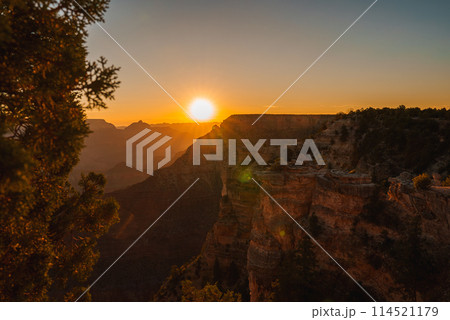 Scenic sunset at Grand Canyon with red rock layers glowing in golden light, vast horizon, and serene atmosphere. Ideal for nature and landscape enthusiasts. Scenic sunset at Grand Canyon with red rock layers glowing in golden light, vast horizon, and serene atmosphere. Ideal for nature and landscape enthusiasts. 114521179