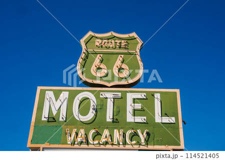 Vintage motel sign featuring iconic Route 66 design against blue sky in Barstow, USA. Classic mid 20th century roadside advertising with nostalgic charm. 114521405