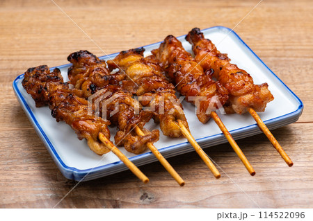 テーブルの上におかれた焼き鳥盛り合せ 114522096