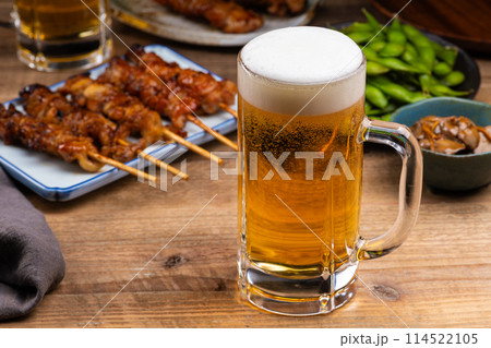 居酒屋のテーブルに並んだビールと料理 114522105